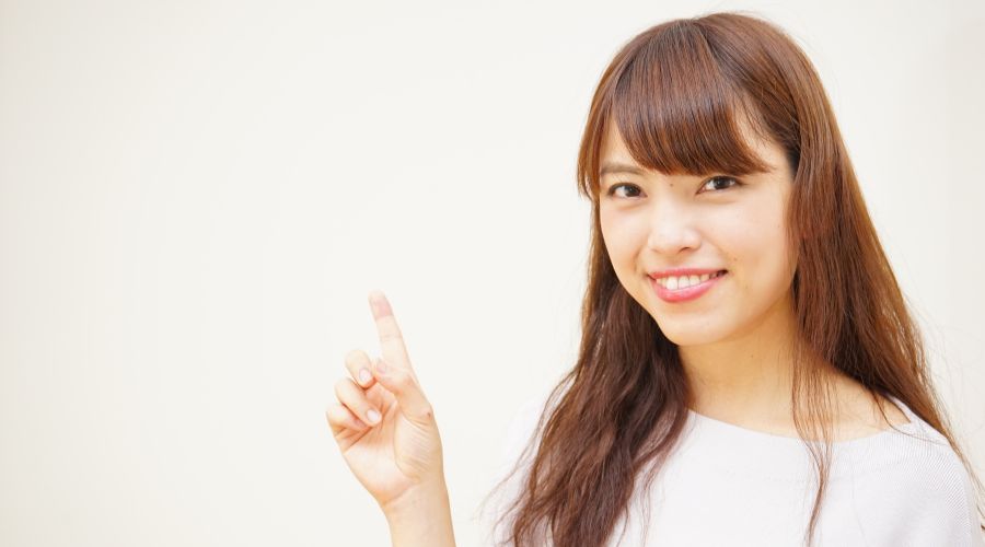 人差し指を差している女性