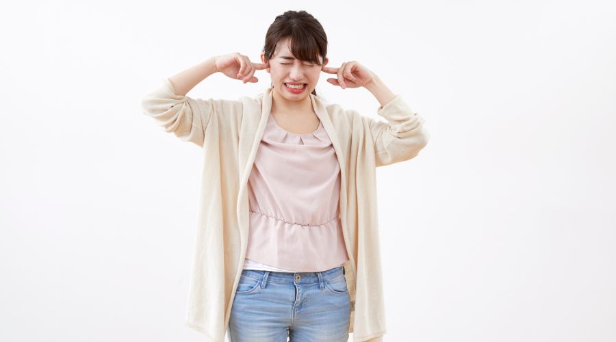 耳を塞いでいる女性