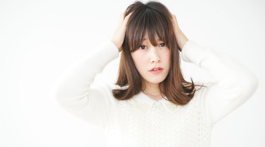 頭を抱えて悩んでいる女性
