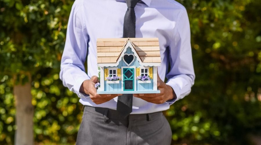 住宅の模型を抱えている営業マン