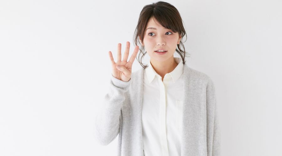 4本指を立てている女性